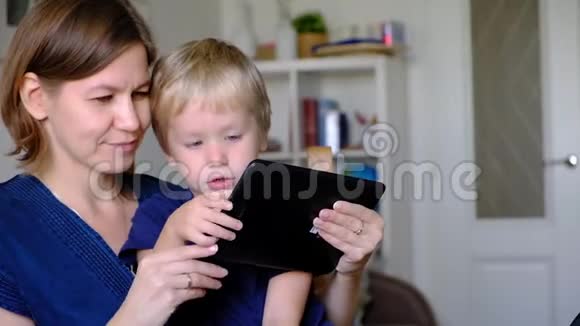 妈妈带着她四岁的儿子玩平板电脑视频的预览图