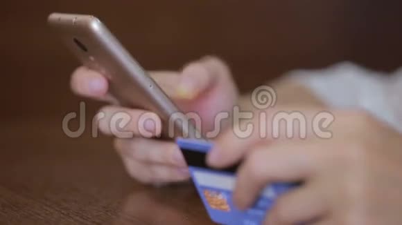 女人用智能手机和银行卡购买视频的预览图