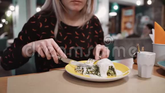 女孩在餐厅吃甜点用叉子和刀视频的预览图