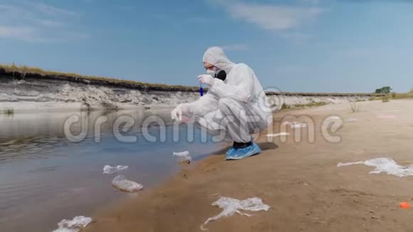 穿着防护服和呼吸器的人观察试管中水的化学反应视频的预览图