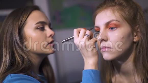 化妆师在家里为一个漂亮的年轻女人化妆视频的预览图