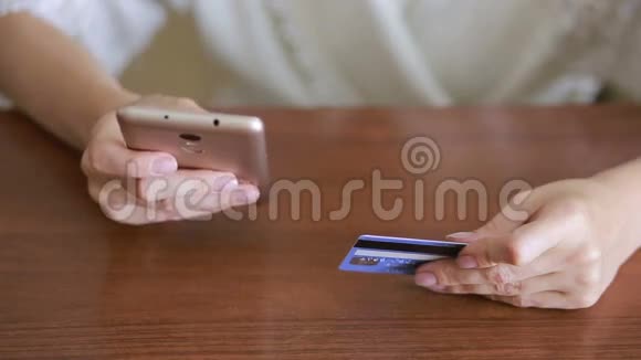 女人用智能手机和银行卡购买视频的预览图