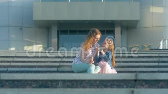 妈妈和女儿在公园里吃冰淇淋妈妈和孩子放松幸福的家庭视频的预览图