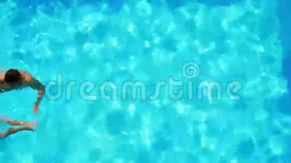 快乐的一对夫妇在清澈的蓝色游泳池游泳视频的预览图
