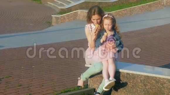 妈妈和女儿在公园里吃冰淇淋母亲和孩子轻松愉快的家庭视频的预览图