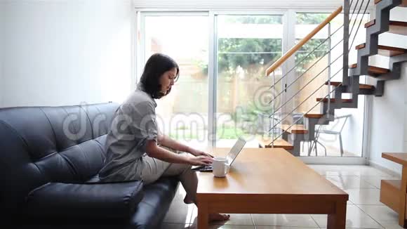 年轻女子在家打手提电脑视频的预览图