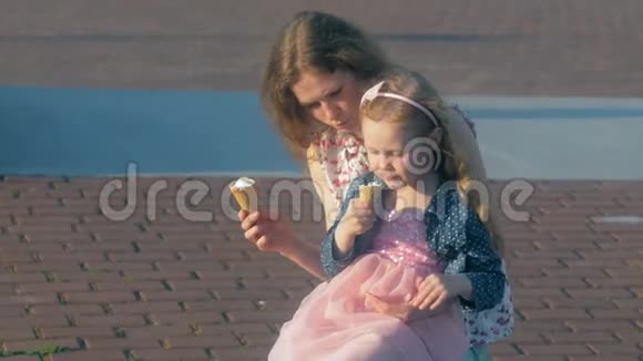 妈妈和女儿在公园里吃冰淇淋妈妈和孩子放松幸福的家庭视频的预览图