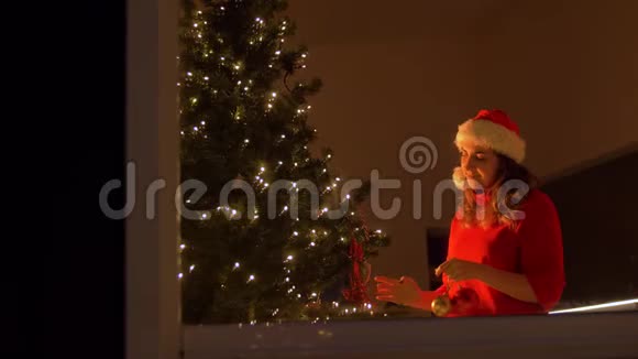 快乐的女人用球装饰圣诞树视频的预览图