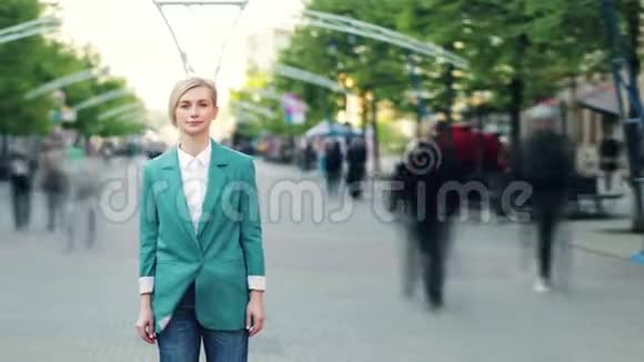 在人群中站在城市街道上的一位严肃的年轻女子的时光流逝画像视频的预览图