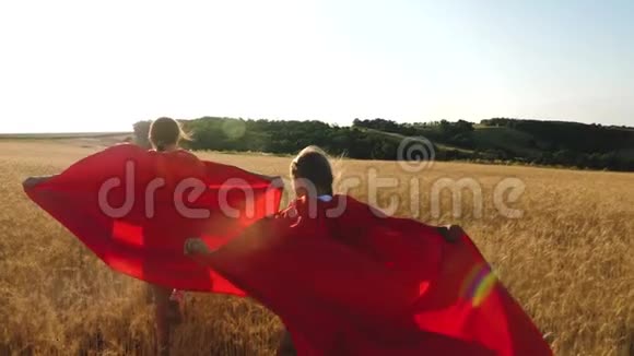 穿着红色斗篷的女孩扮演超级英雄穿过一片成熟的麦田视频的预览图