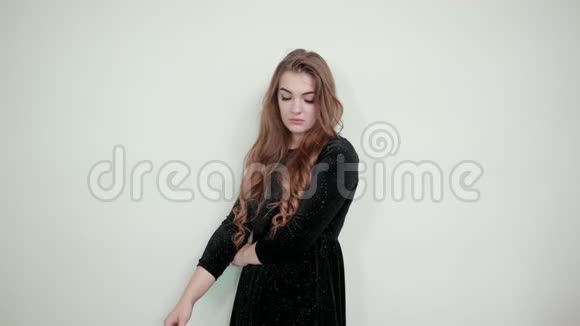 棕色女孩穿着黑色连衣裙在孤立的白色背景下表现出情感视频的预览图