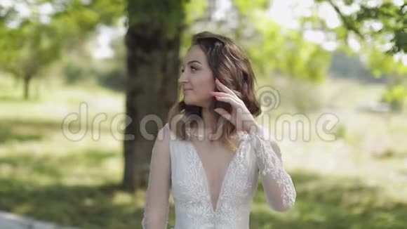 公园里穿着婚纱的美丽可爱的新娘慢动作视频的预览图