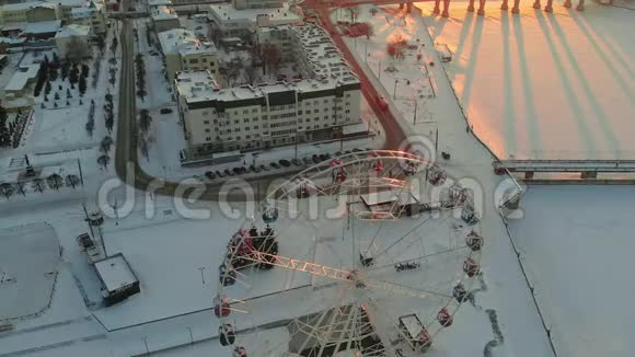 空中拍摄摩天轮日落时的城市景观日出视频的预览图