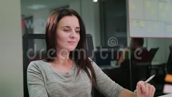 一位坐在办公室的女士在笔记本电脑上打字视频的预览图