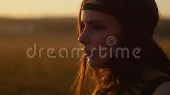 在田野里日落时摆姿势的女孩视频的预览图