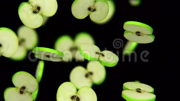 切片绿色苹果落在黑色背景上无缝环CG视频的预览图