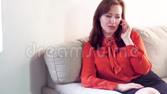 坐在沙发上打电话的女人视频的预览图