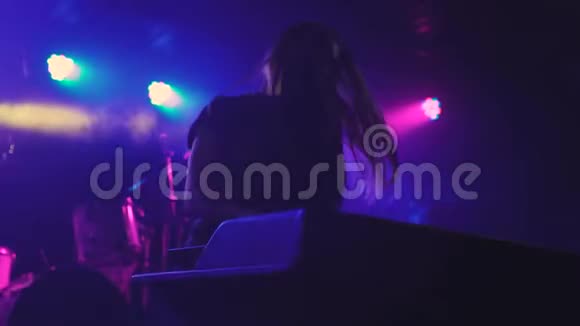 美丽的年轻女子DJ在夜总会的混合控制台播放音乐视频的预览图