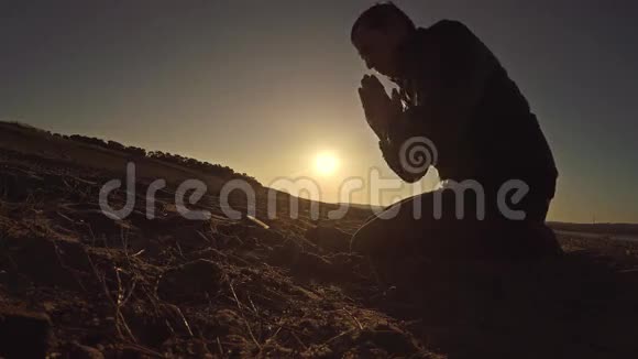 人祈祷上帝日落坐太阳剪影阳光宗教视频的预览图