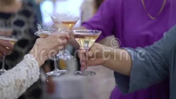 在聚会上人们手里拿着一杯葡萄酒或香槟或其他酒精饮料咯咯地笑着视频的预览图