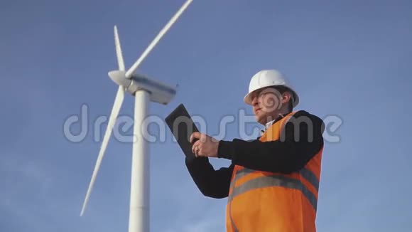 风车能源工程师在日落时与平板电脑合作环境视频的预览图