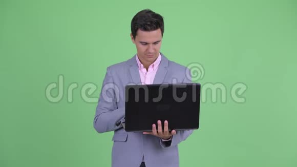 快乐年轻英俊的商人思考笔记本电脑视频的预览图