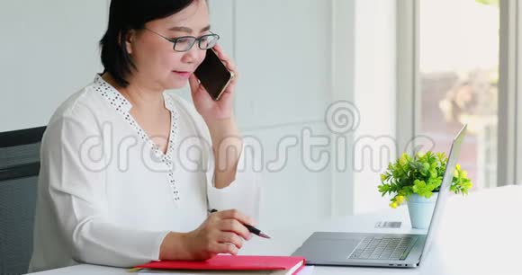 亚洲女商人在办公室里用笔记本电脑视频的预览图