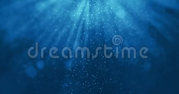 来自水下背景的深蓝色海浪的无缝环路粒子流动光线闪耀视频的预览图