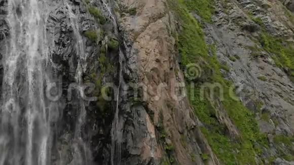 高加索山脉的岩壁上的一股水花瀑布发出的空气视频的预览图