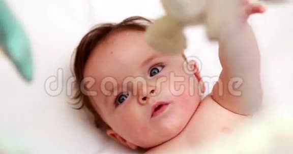 可爱的宝宝在婴儿床上玩手机视频的预览图