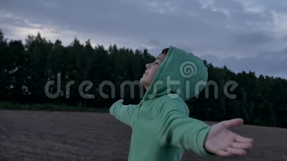 男孩向天空举起双手看着太阳刮风的天气视频的预览图