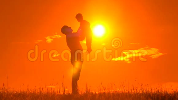 父亲和儿子在公园里玩耍夕阳下一个幸福的家庭剪影视频的预览图