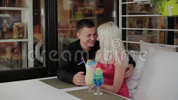 美丽的女孩和男人在晚上的咖啡馆里喝新鲜的鸡尾酒视频的预览图