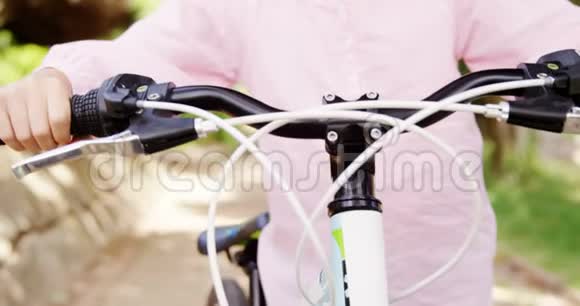 公园里骑自行车的微笑女孩的画像视频的预览图