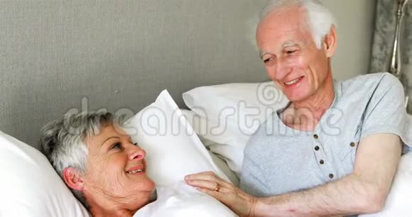 在卧室的床上老夫妇相互交流视频的预览图