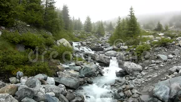 阿尔卑斯山急流上的急流水流过白色的巨石和气泡视频的预览图