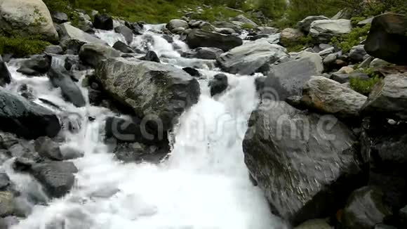 阿尔卑斯山急流上的急流水流过白色的巨石和气泡视频的预览图