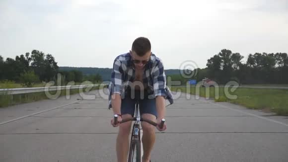年轻英俊的男子骑着老式自行车在乡村道路上运动男在赛道上骑自行车骑自行车的男性视频的预览图