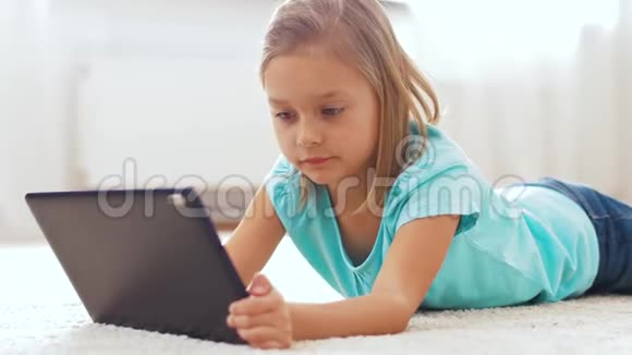 有平板电脑的女孩躺在家里的地板上视频的预览图