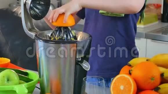 年轻白种人儿童自制新鲜橙汁厨房用电榨汁机视频的预览图