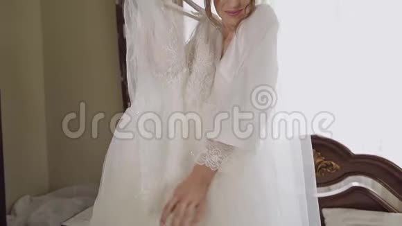美丽可爱的新娘穿着睡衣和面纱结婚礼服慢动作视频的预览图