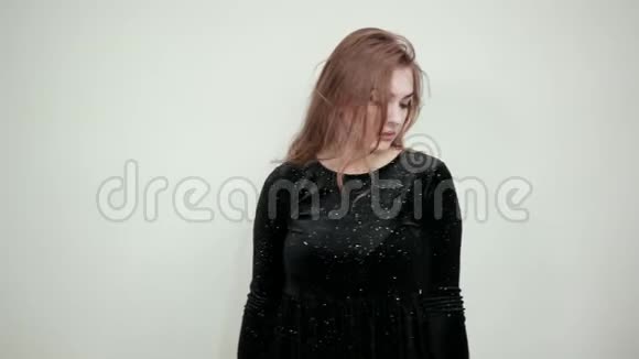 棕色女孩穿着黑色连衣裙在孤立的白色背景下表现出情感视频的预览图