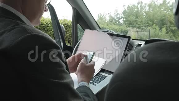 成熟的商人在车上工作手提电脑视频的预览图