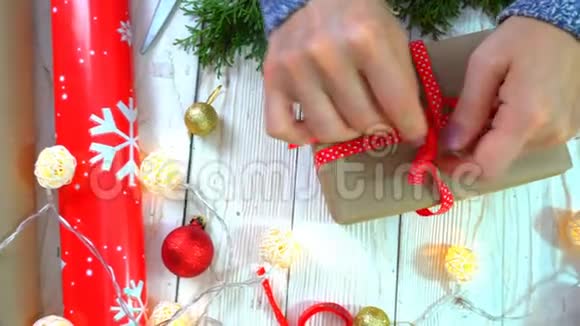 女人正在桌上包装圣诞礼物准备新年和圣诞节假期的概念视频的预览图