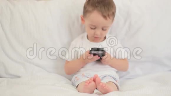 孩子坐着玩智能手机视频的预览图
