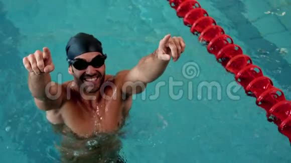 合适的男人在游泳池里举起手臂视频的预览图