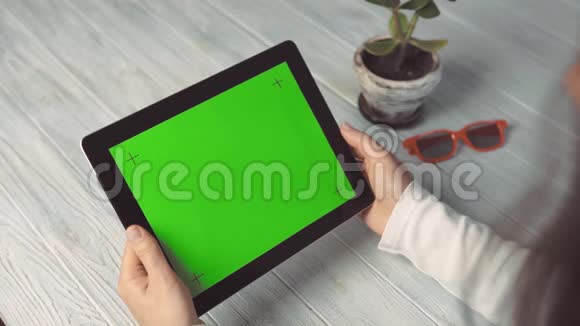 妇女持有平板电脑与绿色屏幕视频的预览图