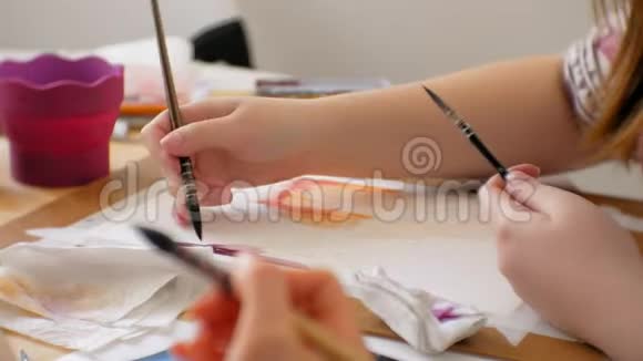年轻女画家在家画室创作工具特写视频的预览图