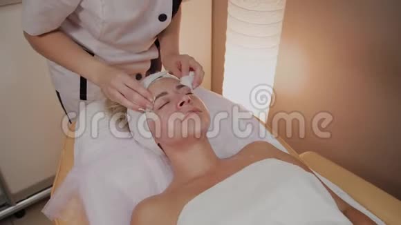 一个女人在美容院用特殊的湿巾清洗视频的预览图