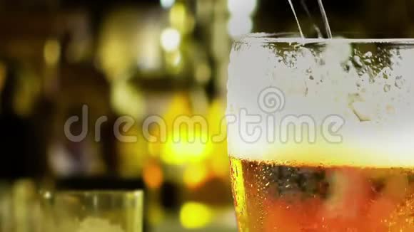 将新鲜啤酒和泡沫倒入桌上的玻璃杯中进入酒吧背景视频的预览图